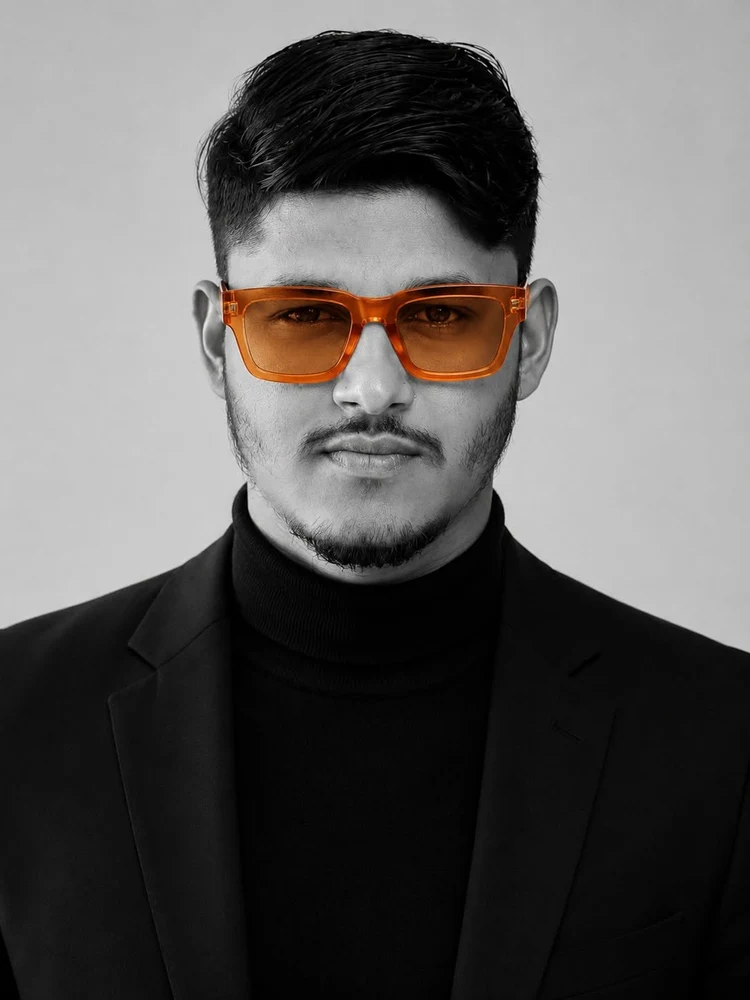 Jayed Ibn Harun in a black jacket and signature orange glasses